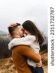 Small photo of a couple in the autumn time having fun traveling. a man holds a girlfriend in his arms. happy couple on high ground. couples autumn vacation