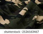 Military camouflage green, black, brown and beige uniform, background
