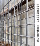 Small photo of High and Mild tensile steel reinforcement bars in grid layout in front of gunnite retaining wall
