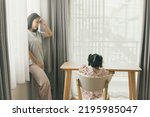 Introverted mother with her daughter in her room : Stressed mother looks at little daughter worried about family problems sad all the time standing think solutions find solution child to be happy.