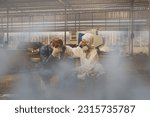 Small photo of Toxic gas leaks from deteriorating gallons in industrial plants suffocate male workers with headaches chemical fumes pour over dangerous areas with female doctors wearing safety gear urgently helping.
