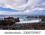 A simple seascape with a rocky shore and azure water