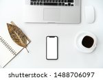 Home office desk workspace with mockup of mobile phone with blank white screen, laptop, cup of coffee, notebook on white background. Flat lay, top view modern minimalist blog header template.