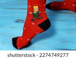 Small photo of Tyumen, Russia-January 23, 2023: Bart Simpson from The Simpsons animated series logo on clothes, Christmas socks