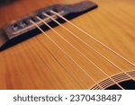 Small photo of Close up of a acoustic guitar string and fingerboard with new strings
