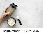 Sport shaker bottle in hands and whey protein in jar. Fitness and gym diet nutrition