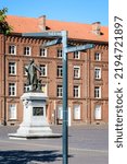 Small photo of Guise, France - August 7, 2022: Statue to Godin and direction signpost showing the different buildings of the Familistere, a phalanstery-type housing complex built by Godin in the 1860s.