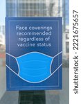 Small photo of Sign to wear a face mask against the glass wall of a building in Austin Texas. CLose up view of a signage informing people that face coverings are recommended regardless of vaccine status.