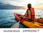 Couple kayaking together. Beautiful young couple kayaking on lake together and smiling at sunset