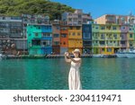 woman traveler visiting in Taiwan, Tourist taking photo by smartphone and sightseeing in Keelung, Colorful Zhengbin Fishing Port, landmark and popular attractions near Taipei city. Asia Travel concept