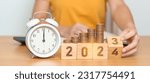 Small photo of Happy New Year with vintage alarm clock and flipping 2023 change to 2024 block. Resolution, Goals, Plan, Action, Money Saving, Retirement fund, Pension, Investment and Financial concept
