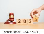 Small photo of 2023 chcnge to 2024 year block with judge gavel on table. Law, lawyer, judgment, justice auction and bidding concept
