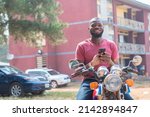 african bike rider smiling and holding his phone