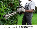 Garden worker in uniform cuts...