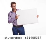 Small photo of Young jocular man portrait of a confident businessman showing presentation, pointing paper placard gray background. Ideal for banners, registration forms, presentation, landings, presenting concept.