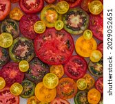 Small photo of Different varieties of orange yellow red tomato, flat lay. Fresh colorful tomatoes background, close up. Best Heirloom Tomato Varieties. Delicious Heirloom tomatoes sliced in half.