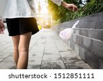 Small photo of Woman’s hand throwing trash on the floor in public areas, people disposed improperly throwing away garbage the way while walking,environmental conservation,plastic pollution,stop using plastic bags