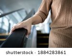 Small photo of Hand of young woman touching the escalator during Coronavirus pandemic,risk of contagious or contamination of COVID-19,virus,bacteria or germs avoid touching handrail of escalator in public places