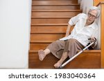 Small photo of Senior woman sitting on the floor of the staircase with pain in hips and back,tripped or lose balance as she walked downstairs causing accidents,old elderly slipped and fell was injured by dizziness