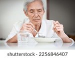 Small photo of Sick asian senior woman suffering from anorexia,bored with meal,eating less food or discomfort in swallowing,disease of Dysphagia,Old elderly patient having lack of appetite,nutrition and health care