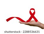 Healthcare and medical, female hand holding red AIDS awareness ribbon. Help red ribbon in support of women's hands for World AIDS Day and National HIV-AIDS Month concept and aging awareness