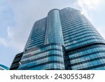 Small photo of Building is located in a city, could be used to represent investment in a number of ways. For example, the skyscraper could represent a company or asset that is worth investing in. Growth. Success.