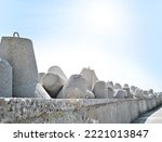 Small photo of Breakwater, concrete stone breakwater blocks in sunlight day on seashore