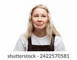 Small photo of A capricious teenage girl. A cute blonde with freckles in a white t-shirt and broun overalls. White background. Close-up. Difficult period in puberty.