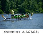 Oarsmen Rowing A Dragon Boat On ...