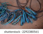 Small photo of Production wiring. Electrical wiring in technical rooms. Electric wires are fastened by a plastic coupler. Cable wiring. Network engineering. Orange and deep blue electric wires.Work as an electrician