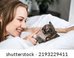 Small photo of Cat Adoption, Adopt kitten from rescues and shelters. Rehome a Cat. Portrait of woman playing with outbred homeless adopted grey kitten