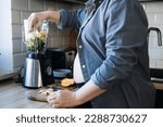 Small photo of Smoothies and food for Pregnancy Nausea. Anti-nausea morning sickness smoothie. Pregnant woman preparing green vitamin smoothie from variety of fruits and vegetables with a blender in kitchen