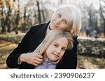 Small photo of Mother-Daughter Relationship. How to Find Common Ground with Teenage Daughters. Happy teen girl walking and playing with her mom in autumn park.