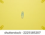 Small photo of Design to yellow clip blocking to whole four corners around the blue clip on yellow paper background. This creative shows the different ideas or paradoxical, and unique. different idea concept.