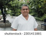 latin senior man portrait looking at camera outdoors in the street in Mexico city, hispanic adult people