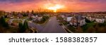 Aerial sunset panorama view of luxury upscale residential neighborhood gated community street in Maryland USA, American real estate with single family homes brick facade colorful sky cul-de-sac