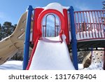 Small photo of Bright red playground slide covered in snow in mid-February. Pretence Park, Ashland, Wis.