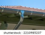 Small photo of zinc gutter silver and pipe house construction new gray metal tile roof with gray rain gutters