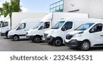 Small photo of Several cars vans trucks parked in parking lot for shipping delivery Outside of Logistics Distributions Warehouse