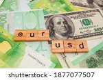 USD EUR inscription on wooden cubes on the texture of us dollars and euro banknotes