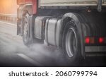Small photo of Truck chassis and wheels on a wet road in rainy weather, close-up. Safety concept and tire grip on wet roads, braking distances under emergency braking, close-up