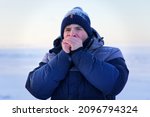 Small photo of Portrait of freezing guy, young handsome frozen man in snow is suffering from cold ice weather, shaking, trembling outdoors at icy snowy day, low temperature, breathing on hands, trying to keep warm
