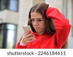 Small photo of portrait of young myopic purblind student teen teenager girl looking at screen of her smartphone, using cell mobile phone in glasses. Vision eyes problems, myopia, blindness.