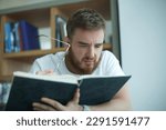 Small photo of tired overworked guy, exhausted young man in glasses college or university student is study hard in library, lesson, problem with eyes, myopic purblind. Vision eyes problems, myopia, blindness.
