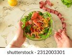 measuring tape, calorie counting software or food delivery on your phone. Green vegan salad from green leaves mix and vegetables. lettuce. diet food, low calories, calorie counting, weight loss.