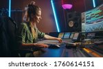 Small photo of Beautiful, Stylish Female Audio Engineer and Producer Working in Music Recording Studio, Uses Mixing Board and Software to Create Cool Song. Creative Girl Artist Musician Working to Produce New Song