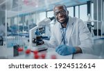 Small photo of Modern Medical Research Laboratory: Portrait of Male Scientist Using Microscope, Charmingly Smiling on Camera. Advanced Scientific Lab for Medicine, Biotechnology, Microbiology Development