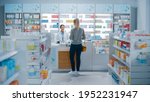Small photo of Pharmacy Drugstore: Beautiful Young Woman Buying Medicine, Drugs, Vitamins Stands next to Checkout Counter. Female Cashier in White Coat Serves Customer. Shelves with Health Care Products