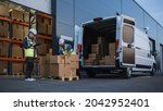 Small photo of Outside of Logistics Distributions Warehouse With Inventory Manager Using Tablet Computer, talking to Worker Loading Delivery Truck with Cardboard Boxes. Online Orders, Purchases, E-Commerce Goods
