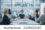 Small photo of Modern Office Meeting Room: Beautiful Asian Executive Director Sits in the Head of the Conference Table and Talks to a Group of Businesspeople, Managers and Investors. People Applaud.